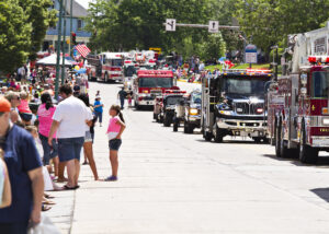 Cranberry Blossom Festival Parade + crowd on side of street watching firetrucks drive by